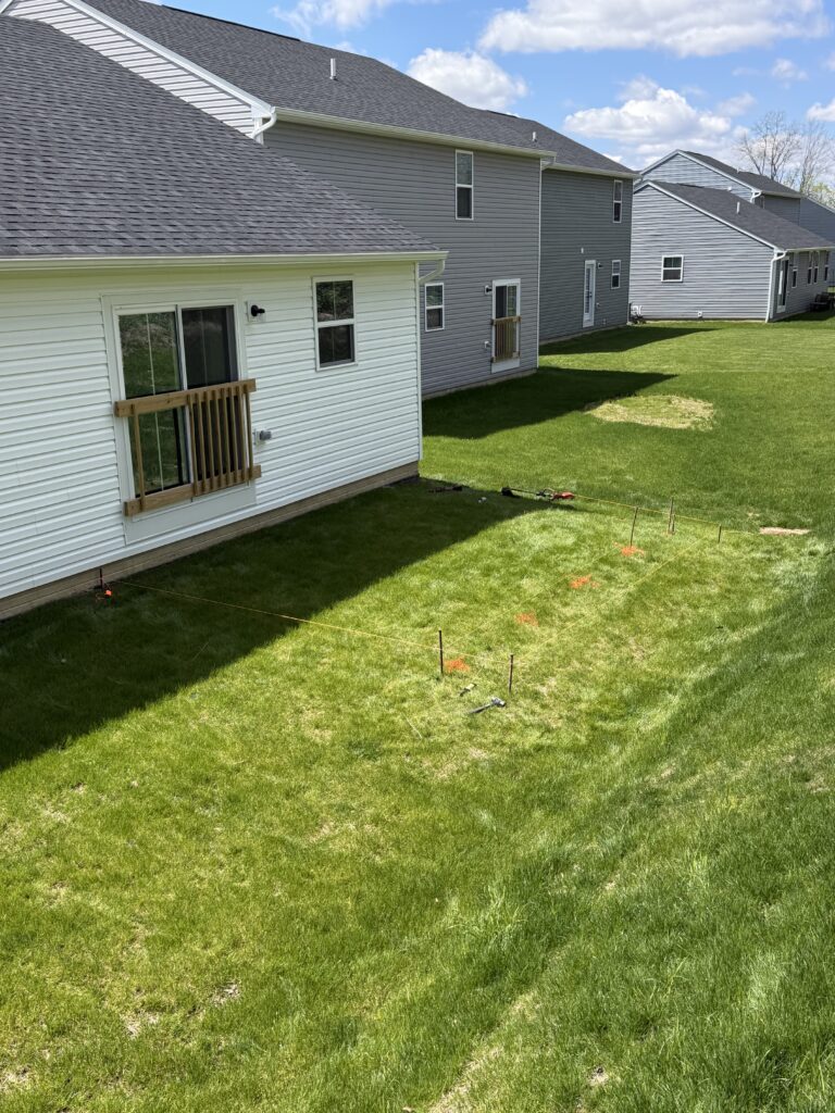 Before photo of a Medina, Ohio backyard during the planning stage of a custom deck installation with the future deck layout and size being mapped out by BJK Construction.